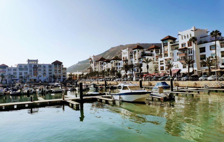 white boat on dock near buildings during daytime