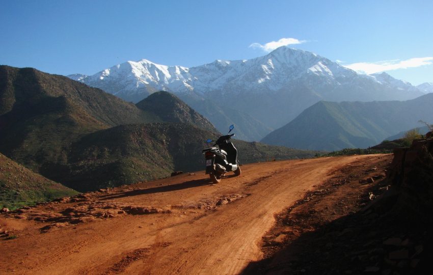 black motor scooter parked on road during daytime